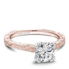 a yellow gold engagement ring with an engraved band and a round diamond in the center