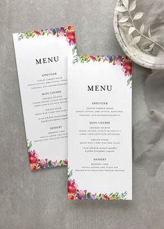 two floral menu cards on top of a table