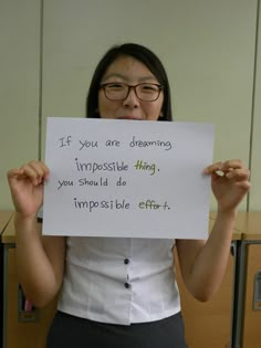 a woman holding up a sign that says if you are dreaming impossibleible things you should do impossiblely effort