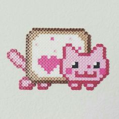 a cross stitch picture frame with a pink and white cat in the middle, on a white background