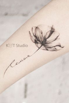 a black and white photo of a flower tattoo on the left arm with words written in cursive writing