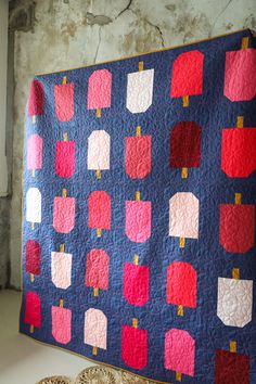 a blue quilt with red and pink squares on it