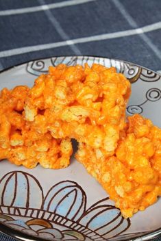 two pieces of macaroni and cheese are on a plate with a blue table cloth