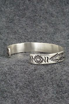 This sterling silver bracelet was made by Navajo silversmith Elvira Bill. The inside is signed Elvira Bill and stamped sterling.Size: 5 7/8" (will fit up to a 7 3/8" wrist)Gap: 1 1/2"Width: 3/8"Free shipping on all orders! We ship with USPS and always include tracking. All orders ship within a day of payment.Returns are accepted up to 30 days after you receive your order. Just send us a message. Our shop offers cash back or store credit. The item must be returned in new condition. Southwestern Sterling Silver Bracelet Stamped 925 As Gift, Silver Artisan Bracelet, Bohemian Etched Sterling Silver Bracelets, Engraved Sterling Silver Bracelet Gift, Handmade Southwestern Silver Bracelets, Southwestern Sterling Silver Bracelet, Sterling Silver Bracelets Gift, Southwestern Style Adjustable Etched Bracelets, Southwestern Style Stamped Sterling Silver Bangle