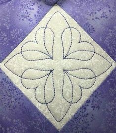 a close up of a purple and white quilt