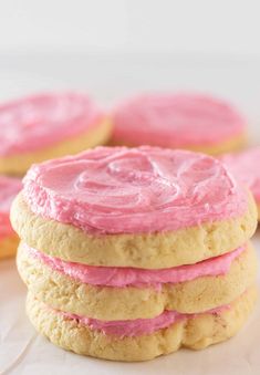 cookies with pink frosting stacked on top of each other