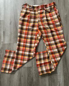 "Vintage Pants  - Burnt Orange  - Rare colour way  - Plaid pattern  - Flared leg  - 60's vintage  - Made in Canada  - MacQueen branded  Polyester/wool/unknown material  65%/25%/10% Size: 34\" waist 30\" inseam  Good vintage condition No rips or holes  No stains" Retro High-waisted Pants For Fall, Fall Retro High-waisted Pants, Retro Plaid Pants For Fall, Retro Straight Leg Pants For Fall, Retro Multicolor Fall Pants, Retro Plaid Wide-leg Pants, Vintage Plaid Pants For Fall, Vintage Pants For Fall, Vintage Trousers For Fall