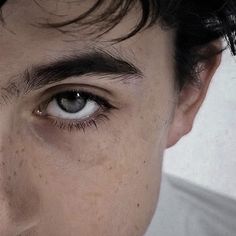 a close up of a man's face with frecky hair and blue eyes