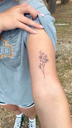 a woman with a flower tattoo on her arm