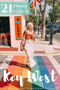 a woman walking down the street in front of a rainbow painted building with text overlay that reads 21 things to do in key west