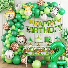 a birthday party with green balloons and jungle animals