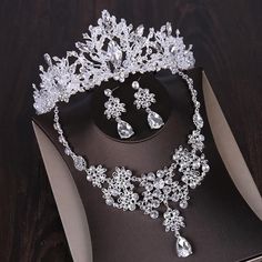 a tiara and earrings are on display in a box with a black tablecloth