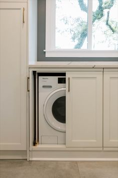 a white washer sitting inside of a kitchen next to a window