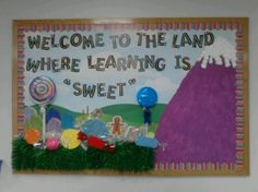 a welcome sign is hanging on the wall in front of a bulletin board that says, welcome to the land where learning is sweet