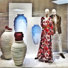 two mannequins are dressed up in dresses and shoes next to vases