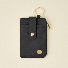 a small black wallet with a gold keychain hanging from it's side