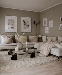 a living room filled with lots of furniture and pictures hanging on the wall above it