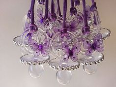 a purple chandelier with glass butterflies hanging from it