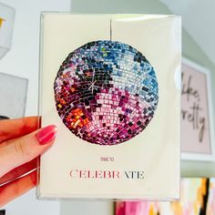 a hand holding up a card with a mosaic design on it's front cover