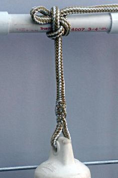 a white bell with a rope hanging from it