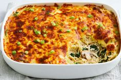 a casserole dish with chicken, noodles and green onions