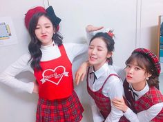 three girls in school uniforms posing for the camera