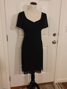 "Vintage Womens Special Occasion Black Lined Spring/Summer Dress Size M-L Excellent Vintage Condition.  Very Clean, No Tears Or Snags.  Shows Little Wear Made By Blushe Spiegel, Marked Size 12 Polyester/Acetate Black Sheer Outer Layer Black Soft Taffeta Lining Sweetheart Neckline Empire Waist Short Semi Sheer Sleeves 16\" Black Nylon Back Hidden Zipper Fabric Hangs Beatifully Knee Length Or Above/Below Depending On Height Bust 40\" Waist 34\" Hips 43\" Sleeves 8\" Length 36\" Weight 14 Oz" Vintage V-neck Evening Dress For Summer, Classic Vintage Evening Dress For Summer, Summer Short Sleeve Mini Evening Dress, Summer Mini Dress With Short Sleeves For Evening, Elegant Vintage Summer Dress For Formal Occasions, Fitted Empire Waist Midi Dress For Cocktail, Elegant Vintage Dress For Summer Formal Occasions, Black Knee-length Vintage Dress, Elegant Vintage Summer Evening Dress