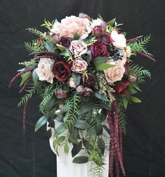 a white vase filled with flowers and greenery