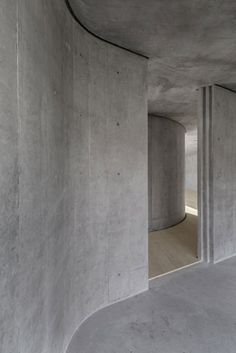 an empty room with concrete walls and wooden floors is seen in this image from the inside