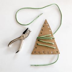 a pair of pliers are next to a christmas tree ornament made out of cardboard