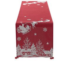 a red table runner with white snowflakes and santa riding a sleigh