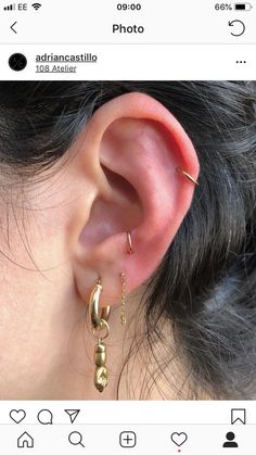 a close up of a person's ear with two gold hoops on it