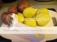 a cutting board with lemons and potatoes on it