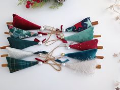 several different types of fabric bows tied to clothes pins on a white surface with christmas decorations in the background