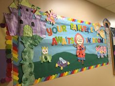 a colorful bulletin board with children's artwork on it in an office building hallway