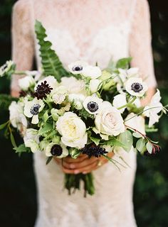 a woman holding a bouquet of white flowers