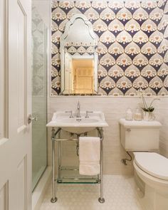 a bathroom with a toilet, sink and mirror