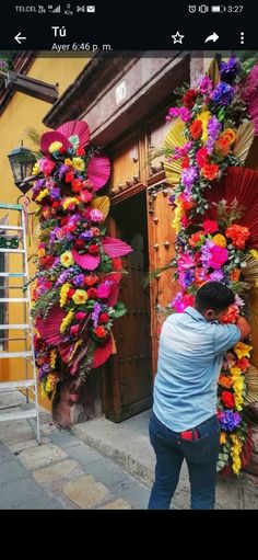 a man standing in front of a building covered in flowers