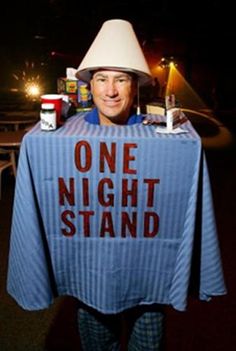 a man with a hat on his head holding a shirt that says one night stand