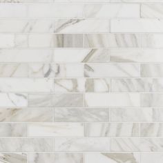 a white marble tile wall that looks like it is being used as a backsplash