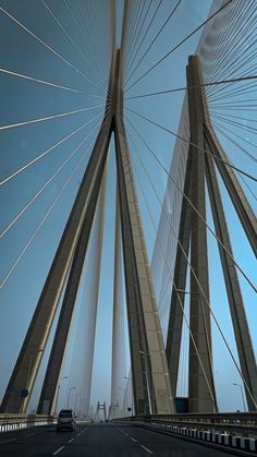 an image of a very tall bridge that is going over the water with cars driving on it