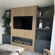 a flat screen tv mounted on the wall in a living room with built - in shelving