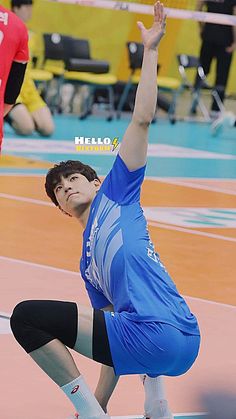 a man in blue shirt and black pants playing volleyball