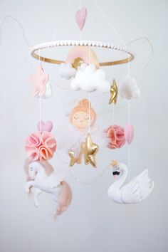 a mobile with pink, white and gold decorations hanging from it