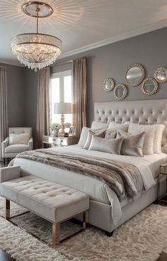 a bedroom with a bed, chair and chandelier