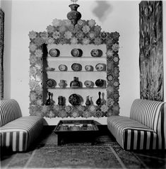 a living room with two chairs and a coffee table in front of a decorative wall