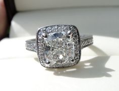 a cushion cut diamond ring with pave set shoulders