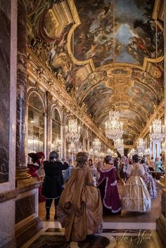 many people in fancy dresses are walking down the hall