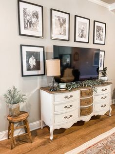 a living room with pictures on the wall and a dresser in front of an entertainment center