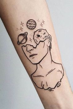 a person with a tattoo on their arm that has an image of a man's face and planets